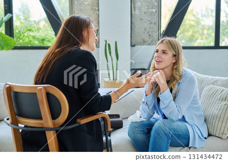 Smiling happy young woman at session with psychologist, therapist 131434472