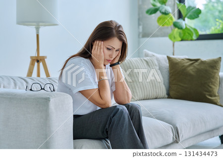 Mature sad woman experiencing stress, mental and physical pain, at home 131434473