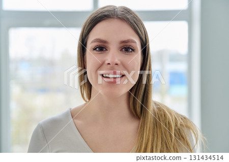 Headshot portrait of young happy woman looking at camera Headshot portrait of young happy woman looking at camera 131434514