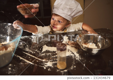 Young Chef Child Bakes Gingerbread With Family in Cozy Kitchen Scene Young Chef Child Bakes Gingerbread With Family in Cozy Kitchen Scene 131434679