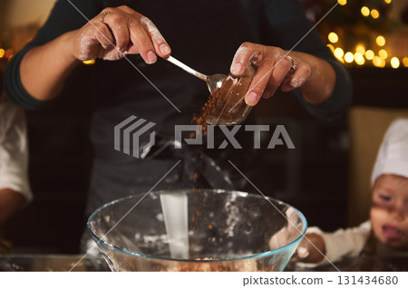 Family Holiday Baking Moment: Hands Pouring Cocoa Into Bowl While Kids Watch Family Holiday Baking Moment: Hands Pouring Cocoa Into Bowl While Kids Watch 131434680
