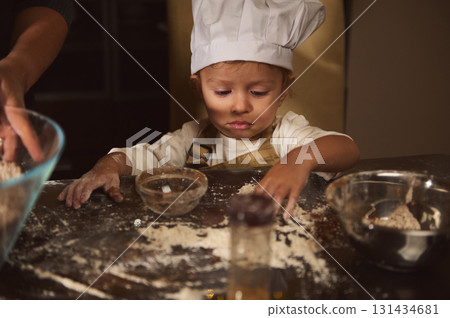 Little Chef Child Cooking Gingerbread With Flour On Kitchen Counter For Christmas 131434681