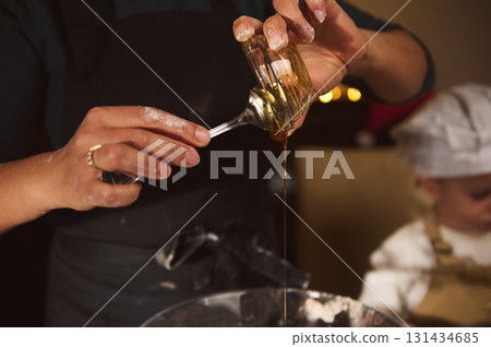 Chef Hands Pour Golden Syrup Into Bowl During Cozy Kitchen Moment Chef Hands Pour Golden Syrup Into Bowl During Cozy Kitchen Moment 131434685