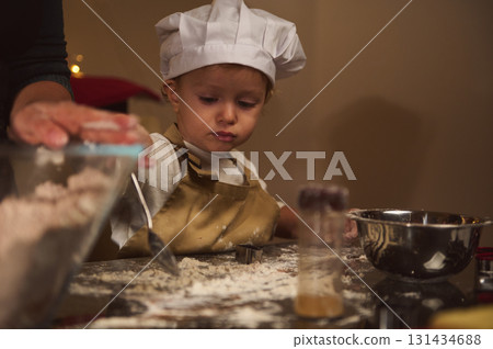 Young Chef Child Helps Bake In Cozy Home Kitchen With Flour, Apron, And Mixing Bowls Young Chef Child Helps Bake In Cozy Home Kitchen With Flour, Apron, And Mixing Bowls 131434688