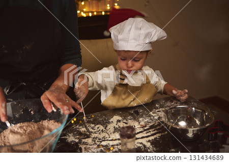 Cute Child Chef Learns Baking With Parent In A Cozy Christmas Kitchen Cute Child Chef Learns Baking With Parent In A Cozy Christmas Kitchen 131434689