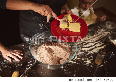 Mother And Child Baking In The Kitchen With Butter And Flour For Gingerbread Cookies Today Mother And Child Baking In The Kitchen With Butter And Flour For Gingerbread Cookies Today 131434690