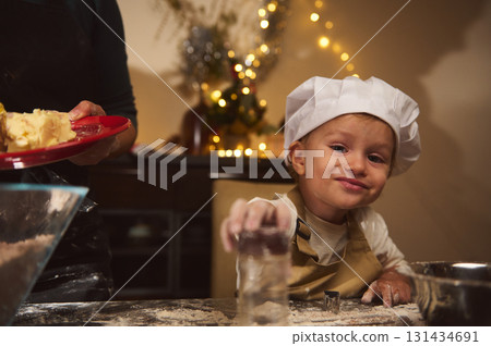 Young Chef Child Helps Family Bake Christmas Treats in Cozy Home Kitchen 131434691