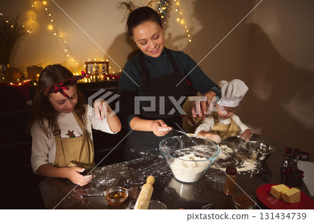 Happy Family Baking Christmas Cookies And Gingerbread In Cozy Home Kitchen With Fairy Lights Happy Family Baking Christmas Cookies And Gingerbread In Cozy Home Kitchen With Fairy Lights 131434739