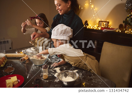 Joyful Family Baking Gingerbread Cookies And Building Christmas Village Together At Home Joyful Family Baking Gingerbread Cookies And Building Christmas Village Together At Home 131434742