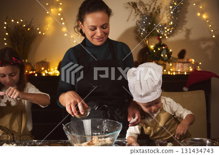 Joyful Mom And Kids Bake Gingerbread House Together For Christmas In Cozy Home 131434743