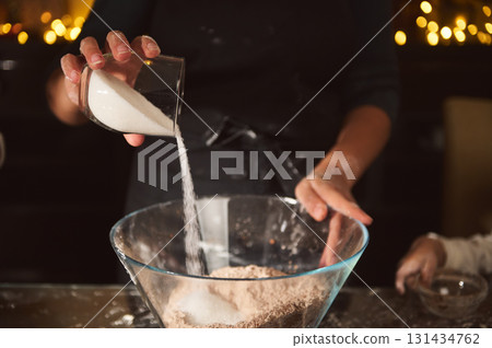 Hands Pour Sugar Into A Glass Bowl During Cozy Home Kitchen Baking Scene Hands Pour Sugar Into A Glass Bowl During Cozy Home Kitchen Baking Scene 131434762