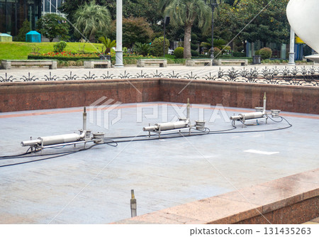 Empty fountain in a city park. Dehumidification. Cleaning the fountain with a hose. The device of the fountain. Pipes for water supply. Water hoses. Modern technologie 131435263