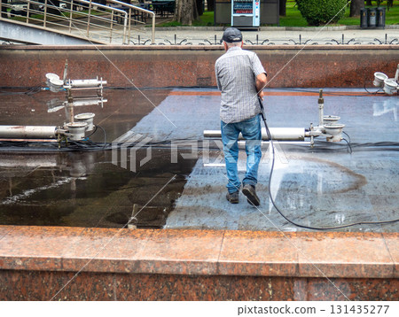 Empty fountain in a city park. Dehumidification. Cleaning the fountain with a hose. The device of the fountain. Pipes for water supply. Water hoses. Modern technologies. Infrastructure maintenance. Empty fountain in a city park. Dehumidification. Cleaning the fountain with a hose. The device of the fountain. Pipes for water supply. Water hoses. Modern technologies. Infrastructure maintenance. 131435277