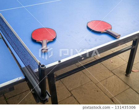 Ping pong tables in the park. Table tennis rackets on a table in the park. The concept of the end of the game. holiday at the resort. 131435306