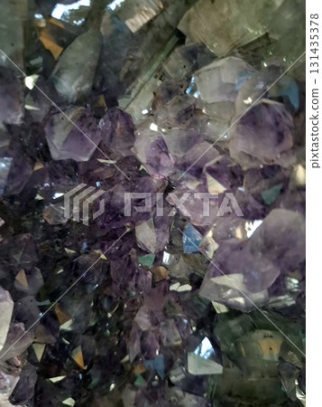 The picture captures the intricate texture of amethyst crystals. The shining purple and transparent facets create a stunning visual display that highlights natural beauty and geological formation. 131435378