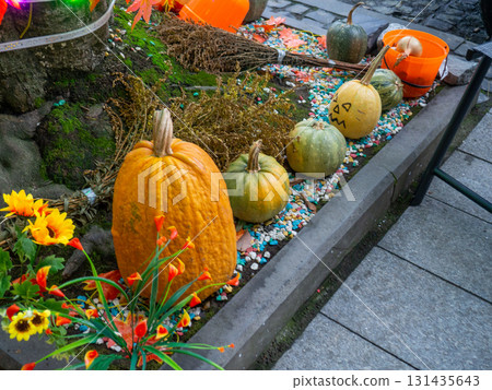 Decorations for Halloween on the street near the restaurant. Pumpkins are placed near the tree. Restaurant patio decoration. Painted multi-colored pumpkins. All Saints' Day. The holiday is 131435643