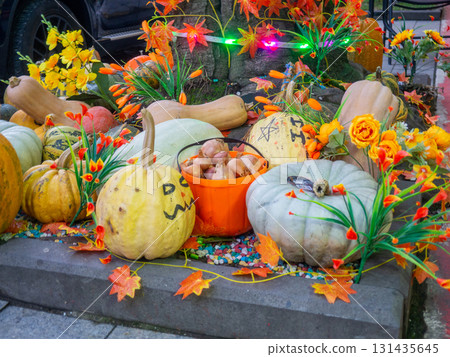 Decorations for Halloween on the street near the restaurant. Pumpkins are placed near the tree. Restaurant patio decoration. Painted multi-colored pumpkins. All Saints' Day. The holiday is approaching Decorations for Halloween on the street near the restaurant. Pumpkins are placed near the tree. Restaurant patio decoration. Painted multi-colored pumpkins. All Saints' Day. The holiday is approaching 131435645