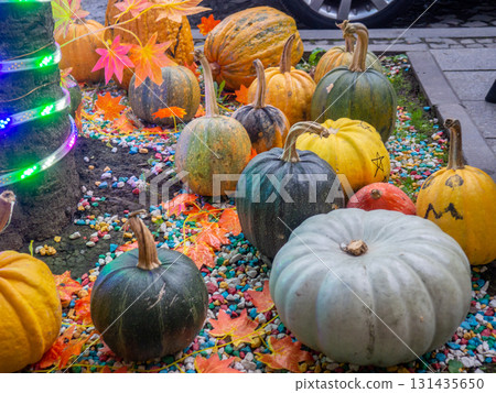 Decorations for Halloween on the street near the restaurant. Autumn holiday decorations. Illuminations. Restaurant patio decoration. Painted multi-colored pumpkins. All Saints' Day. The holiday is 131435650