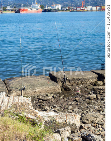 Fishing rods on the seashore. Fishing. Waiting for a bite. Bottom fishing. Fishing rods on the seashore. Fishing. Waiting for a bite. Bottom fishing. 131435951