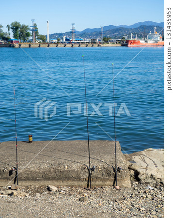 Fishing rods on the seashore. Fishing. Waiting for a bite. Bottom fishing. Fishing rods on the seashore. Fishing. Waiting for a bite. Bottom fishing. 131435953
