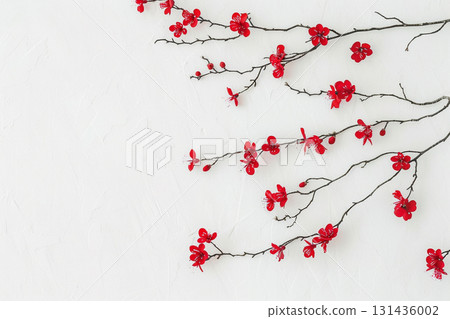 Japanese style background of red plum branches and flowers blooming on a white background Japanese style background of red plum branches and flowers blooming on a white background 131436002