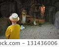 Good leisure for a child. Teaching a child through play. A handsome boy 3 oldl in a yellow jacket excavates the remains of dinosaurs. High quality photo. 131436006