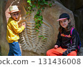 Good leisure for a child. Teaching a child through play. A handsome boy 3 oldl in a yellow jacket excavates the remains of dinosaurs. High quality photo. 131436008