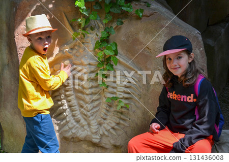 Good leisure for a child. Teaching a child through play. A handsome boy 3 oldl in a yellow jacket excavates the remains of dinosaurs. High quality photo. Good leisure for a child. Teaching a child through play. A handsome boy 3 oldl in a yellow jacket excavates the remains of dinosaurs. High quality photo. 131436008