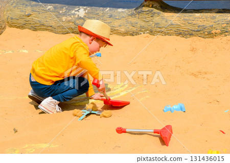 Boy and girl playing on the beach on summer holidays. Children building a sandcastle at the sea. High quality photo 131436015