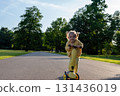 Child with scooter. Yellow riding toddler fun. Summer activity outdoor road. 131436019