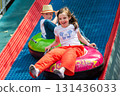 Kids having fun in ferris wheel with chains, carousel ski flyer in amusement park in Targoviste, Romania, 2020. High quality photo 131436033