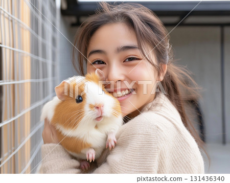 Cuddling guinea pig with a smiling young friend outdoors, cute and fluffy animal companion Cuddling guinea pig with a smiling young friend outdoors, cute and fluffy animal companion 131436340