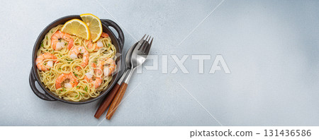 Delicious seafood pasta spaghetti with shrimps dish garnished with lemon and parsley top view on white background, space for text Delicious seafood pasta spaghetti with shrimps dish garnished with lemon and parsley top view on white background, space for text 131436586