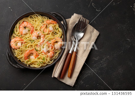 Delicious seafood pasta spaghetti with shrimps dish garnished with lemon and parsley top view on black background, space for text 131436595