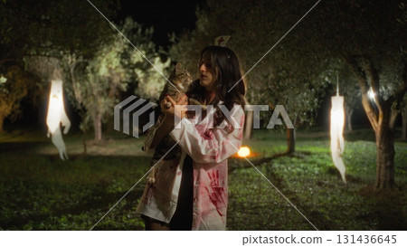 Zombie Woman Pets Her Cat In The Forest On Halloween Night 131436645