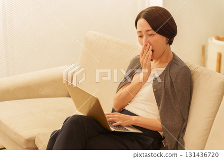 Sleep-deprived woman working on a computer at night 131436720