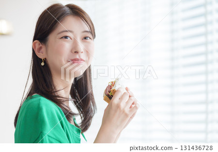 A woman eating a sandwich 131436728