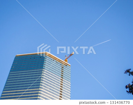 A newly built house. Glazed skyscraper. Reflection of the sky in the windows. Multi-apartment modern housing. A newly built house. Glazed skyscraper. Reflection of the sky in the windows. Multi-apartment modern housing. 131436770