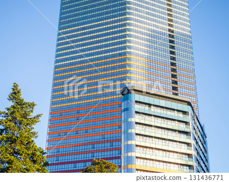 A newly built house. Glazed skyscraper. Reflection of the sky in the windows. Multi-apartment modern housing. A newly built house. Glazed skyscraper. Reflection of the sky in the windows. Multi-apartment modern housing. 131436771