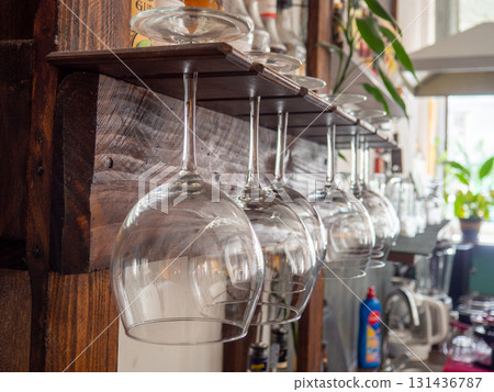 Glasses hang over the bar counter. The glasses are turned upside down. restaurant interior. Concept of drinking alcoholic beverages. Glass glasses for wine. Glasses hang over the bar counter. The glasses are turned upside down. restaurant interior. Concept of drinking alcoholic beverages. Glass glasses for wine. 131436787