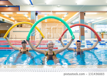 Female group enjoying water workout with aqua sticks 131436883