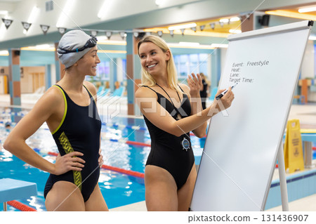 Aquatic trainer preparing female athlete with plan for freestyle event Aquatic trainer preparing female athlete with plan for freestyle event 131436907