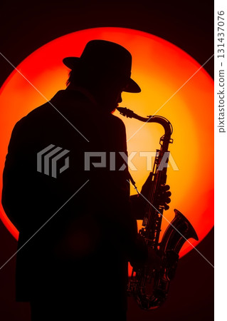 silhouette of saxophone player with orange backdrop silhouette of saxophone player with orange backdrop 131437076