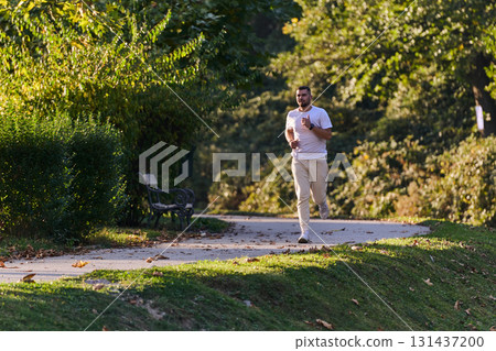 A handsome man maintains his healthy lifestyle as he runs along beautiful natural trails, embodying the essence of fitness, wellness, and vitality in the midst of scenic outdoor surroundings. 131437200