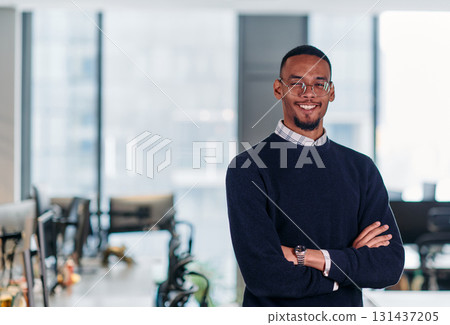 Confident African American Businessman Posing in Modern Startup Office. Confident African American Businessman Posing in Modern Startup Office. 131437205