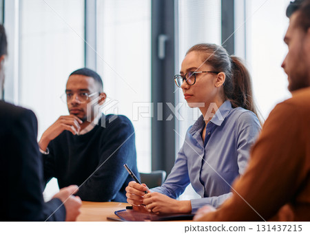 In the vibrant ambiance of a modern startup office, a diverse team of business professionals engage in discussions on various projects and develop new business strategies, epitomizing creativity and In the vibrant ambiance of a modern startup office, a diverse team of business professionals engage in discussions on various projects and develop new business strategies, epitomizing creativity and 131437215