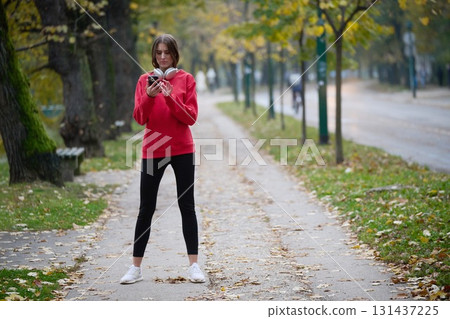 Athletic young woman taking a breath and relaxing after jogging and stretching. Woman Training and Workout Exercises On Street. 131437225