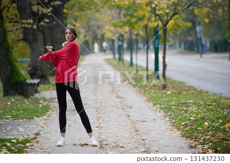 Athletic young woman taking a breath and relaxing after jogging and stretching. Woman Training and Workout Exercises On Street. Athletic young woman taking a breath and relaxing after jogging and stretching. Woman Training and Workout Exercises On Street. 131437230