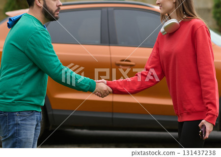 Car keys handshake, seller or car salesman and customer in a dealership, shake hands over the car keys Car keys handshake, seller or car salesman and customer in a dealership, shake hands over the car keys 131437238