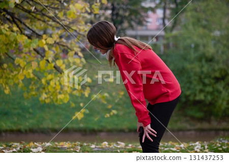 Athletic young woman taking a breath and relaxing after jogging and stretching. Woman Training and Workout Exercises On Street. 131437253